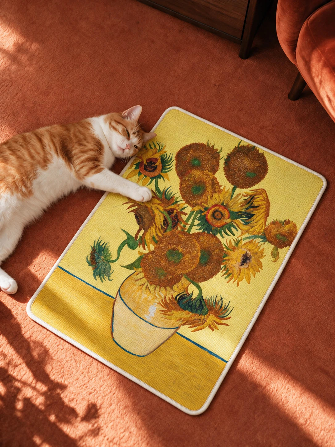Cat resting beside the Sunflowers art scratcher on a terracotta rug